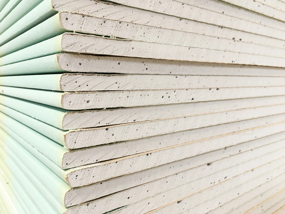 Homme en chemise &agrave; carreaux installant des &eacute;quipements dans cuisine moderne blanche