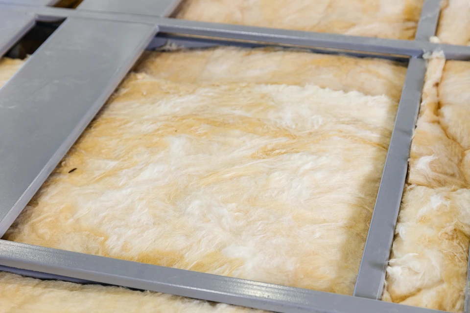 Atelier de construction intérieur avec matériaux isolants verts disposés sur surface de travail