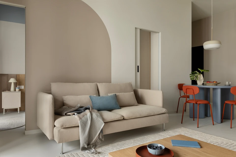 Le salon moderne est décoré dans des tons blancs clairs avec une cloison transparente en métal foncé en verre et des lampes au plafond