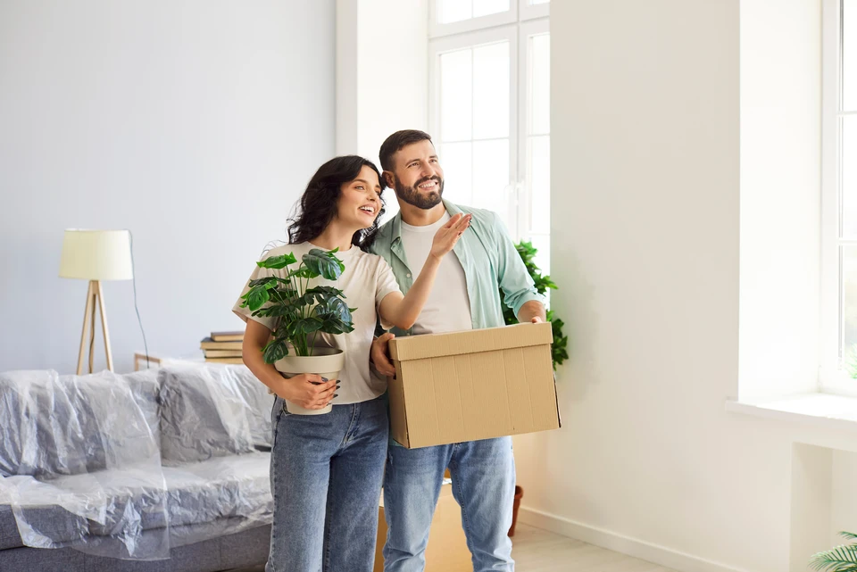 Ouvrier en bâtiment appliquant un enduit de lissage sur mur intérieur avec une taloche inox